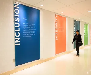 Person walking in front of Principles of Community banners